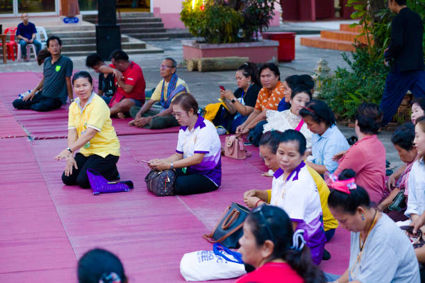 sentado e esperando de um grupo de mulheres tailandesas maduras se juntando na cerimônia budista - true thailand classic - fotografias e filmes do acervo