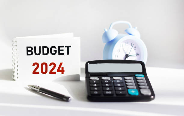 istock BUDGET 2024 written on a notepad and white background and with a calculator clock 1870052116