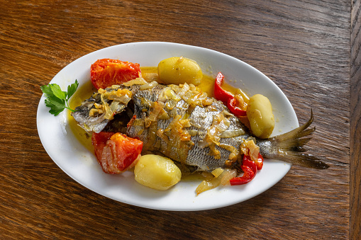 Delicious roasted red snapper with potatoes and red bell pepper.