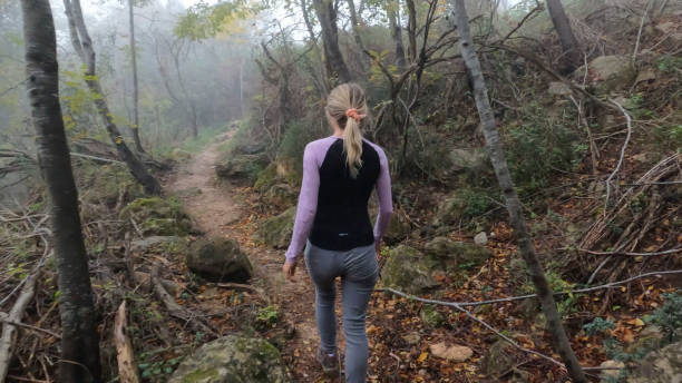 istock Young woman hikes up path in forest 1870067301
