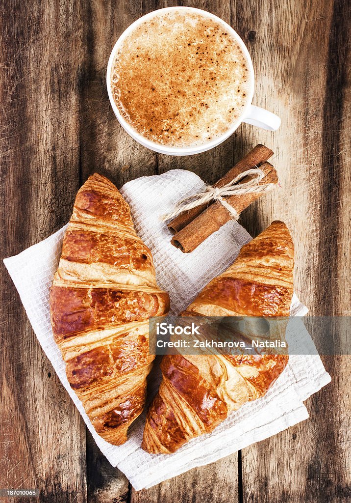 Frühstück mit Croissants und Kaffee auf Holz Rustikal-Hintergrund - Lizenzfrei Altertümlich Stock-Foto