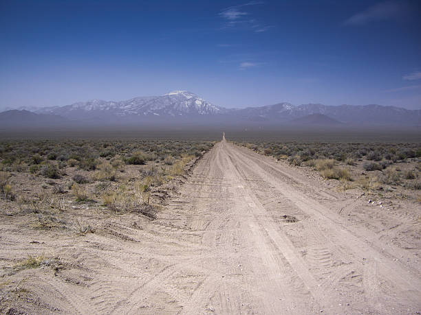 Desert vista of snowy mountains from a dirt road Nevada USA