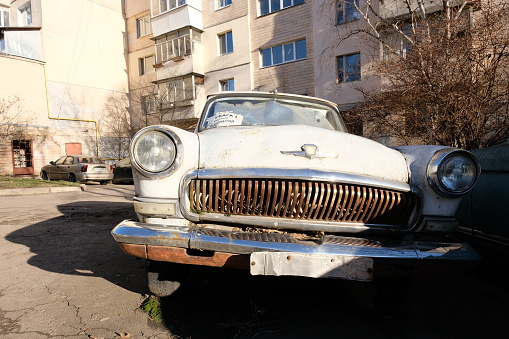 Kyiv, Ukraine - December 20 2023: old rusty Soviet car Volga parked on street