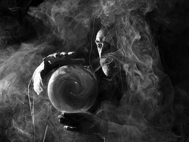 Fortune teller in fantastical costume holding crystal ball Fortune teller in fantastical costume holding crystal ball, smoky atmosphere fortune teller photos stock pictures, royalty-free photos & images