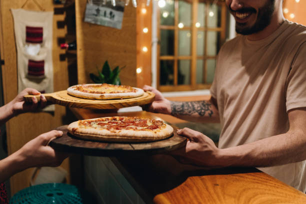Man picking up trays with pizza for dinner at home