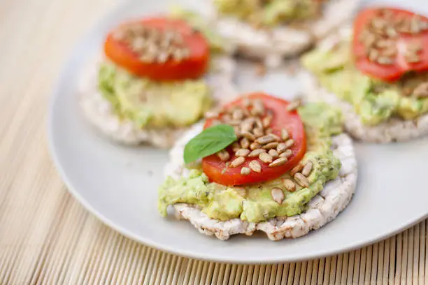 Guacamole, tomatoes on rice cakes.