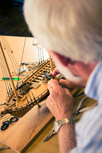 istock Model Ship Builder Working on A Wooden Sailboat 187016521