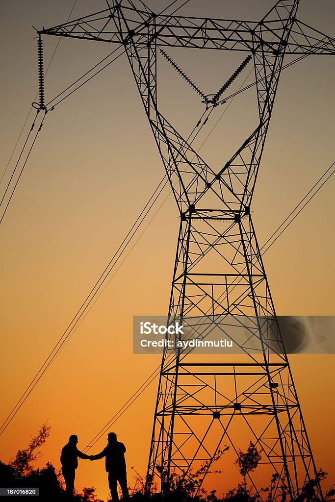 Linhas de energia e aperto de mão - Foto de stock de Eletricidade royalty-free