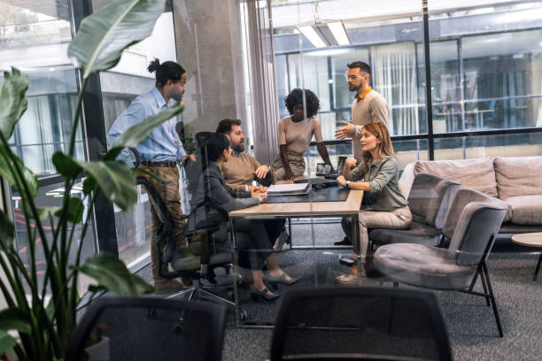 istock International workers group and team leader having teamwork discussion managing project at work in meeting room. 1870172479
