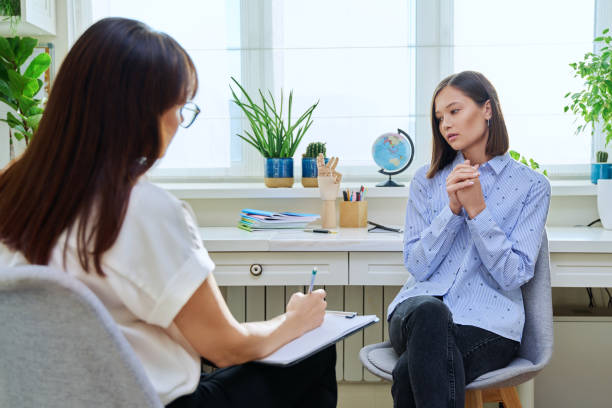 istock Sad stressed young woman in therapy with psychologist 1870174083