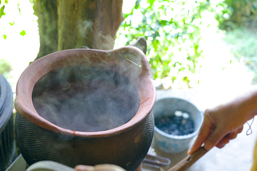 Boiling  thai herbal health water for foot bathing  into cauldron on fireplace in Chianfg Rai province