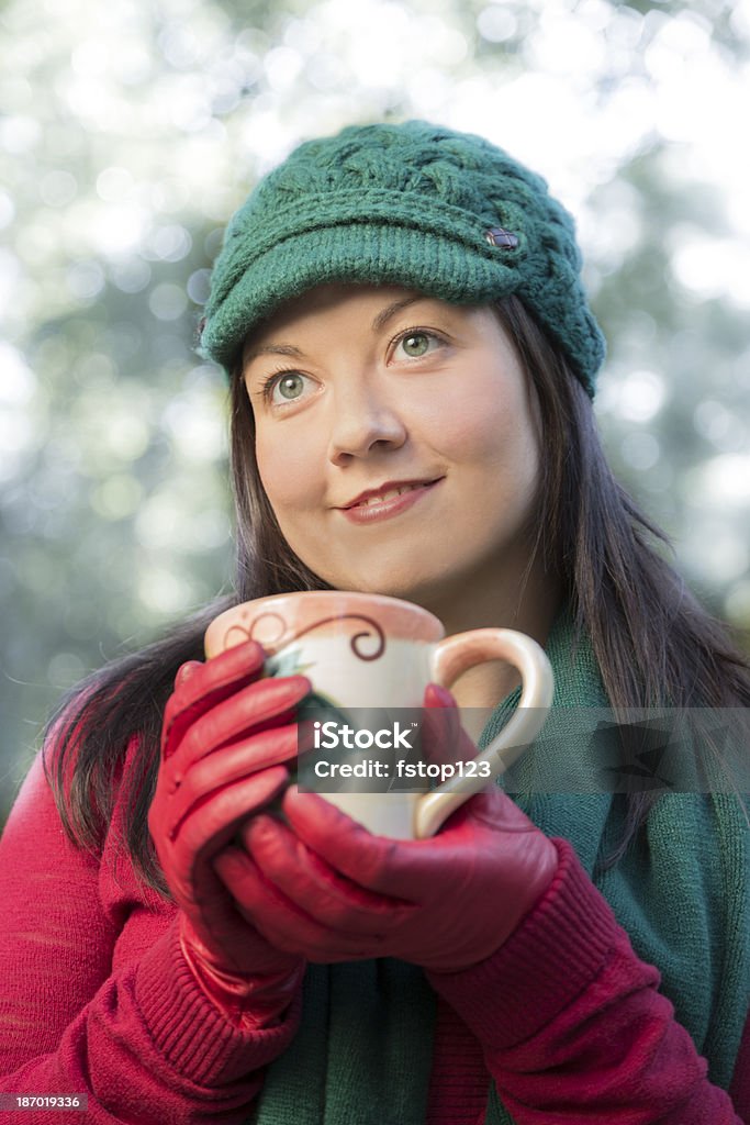 ドリンク： 若い女性は冬はホットコーヒーをお召し上がりいただけます。 - 1人のロイヤリティフリーストックフォト