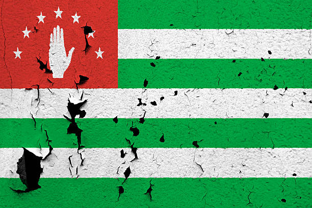 The flag of Abkhazia painted on a cracked and peeling wall.