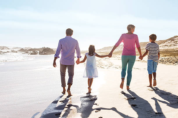 istock Children And Parents Holding Hands While Walking On Beach 187020696