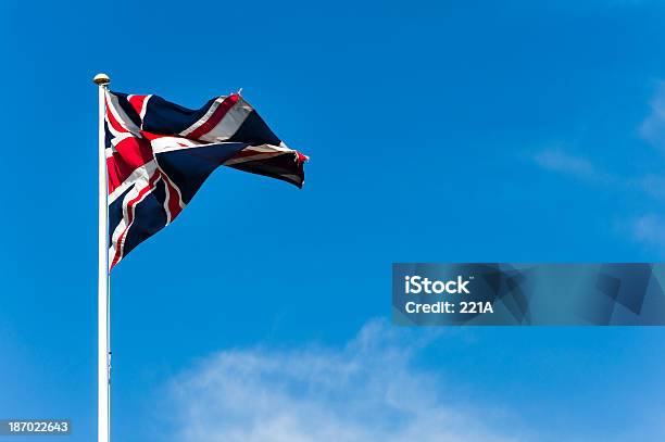 Union Jack Volando Contra El Cielo Azul On A Windy Day Foto de stock y más banco de imágenes de Aire libre