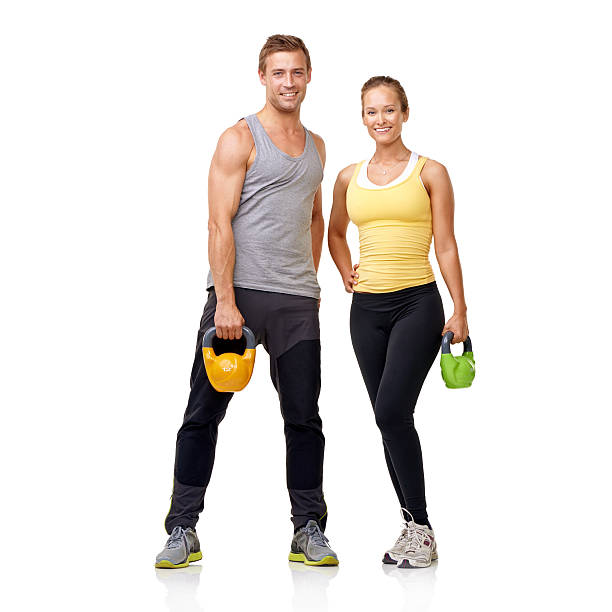 Two gym partners standing together holding kettlebells