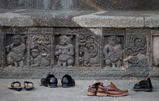 Shoes are placed next to carvings at the Ajanta Caves  in Aurangabad district of Maharashtra, India, where about 300 rock-cut Buddhist cave monuments date from the 2nd century BCE to about 480 or 650 CE.