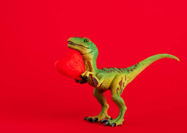 istock Green cute dinosaur with red heart on  red background. Creative minimal greeting card on Valentines day. Love concept. 1870234634