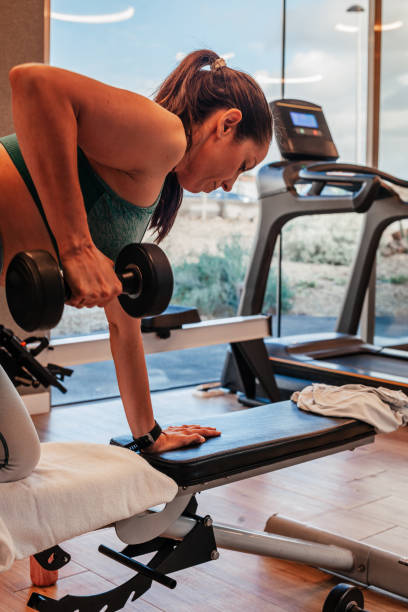 istock Woman in the gym training with dumbbells 1870234656