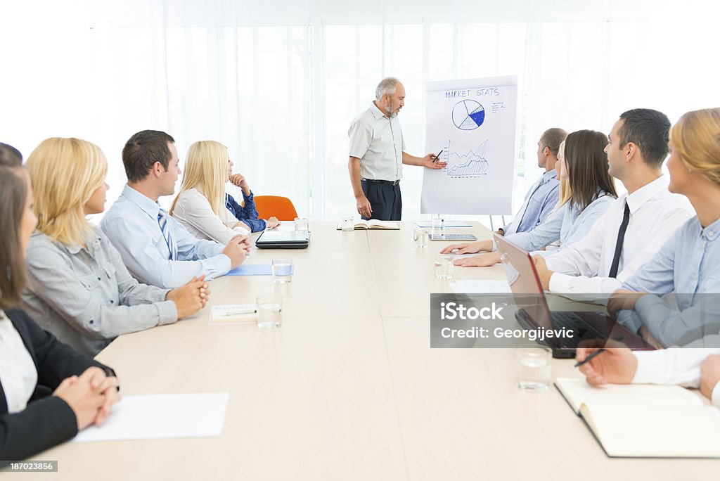 Senior Uomo d'affari che punta alla lavagna a fogli mobili - Foto stock royalty-free di Abbigliamento da lavoro