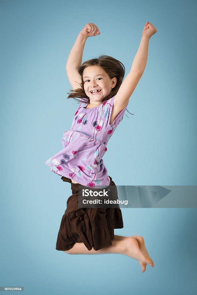 Цветное изображение восьми лет Девушка Прыжки на Joy - Стоковые фото Прыгать роялти-фри