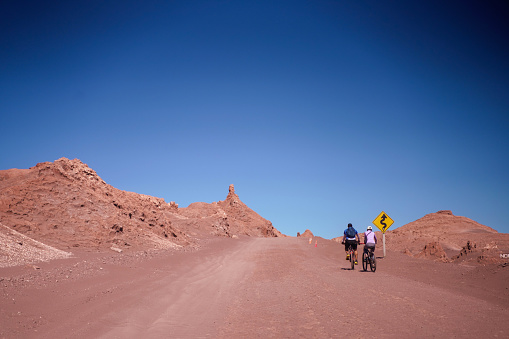 San Pedro de Atacama, Chile - October 26, 2023: Cyclists exploring the Moon Valley (Spanish: Valle de La Luna ) in the Atacama Desert near San Pedro de Atacama, northern Chile, South America.