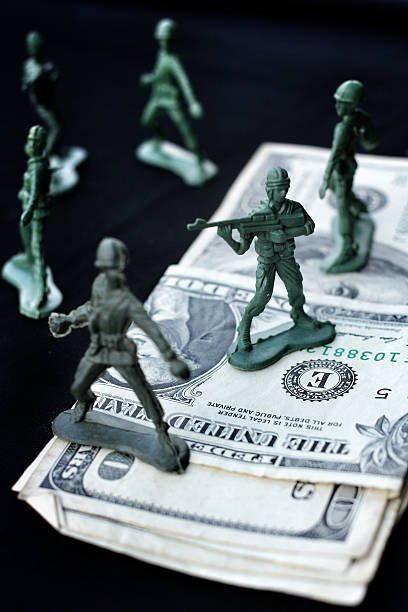 istock toy soldier standing with dollar 187025124