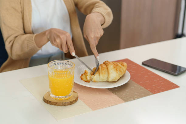 istock Happy woman having breakfast crispy croissants 1870259364