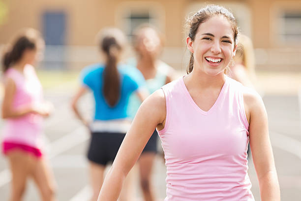 Happy high school student standing on track before big race
