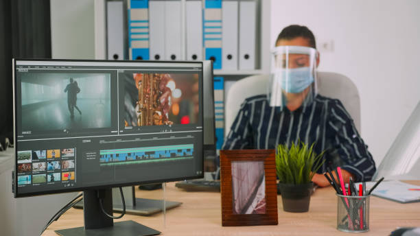 istock Videographers with protection masks working at video project 1870314599