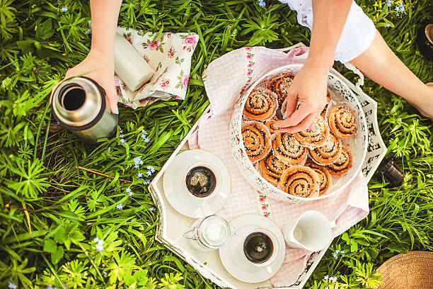 picnic outdoors with coffee and cinnamon buns - cinnamon buns people bildbanksfoton och bilder