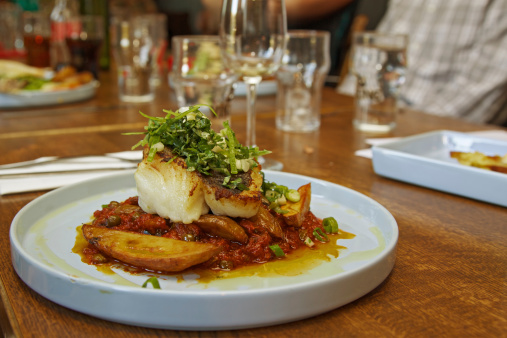 A mouthwatering dish with Cod fish and tomatoes in a restaurant in Flateyri. The Westfjords. Iceland.