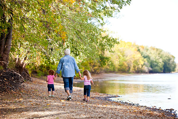 dos chicas caminando por el río & grandma - ribera fotografías e imágenes de stock