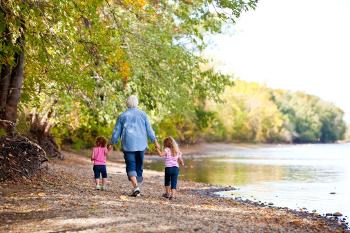 Hike, nature and children with senior foster parents and their adopted son walking on a sand path through the tress. Family, hiking and kids with an elderly man, woman and boy taking a walk outside