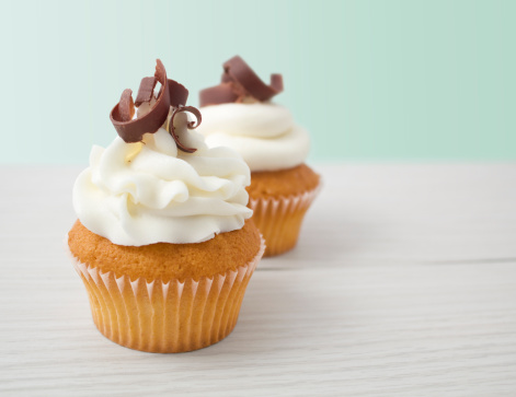 Cupcakes topped with a vanilla buttercream frosting and dark chocolate curls.