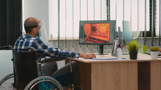 istock Handicapped game developer in wheelchair with mask working 1870326727