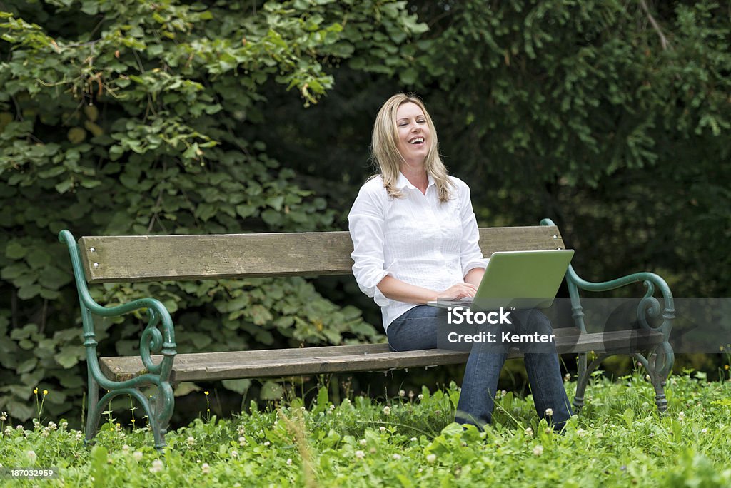 Rir Jovem mulher com laptop no Banco de Parque - Royalty-free Ao Ar Livre Foto de stock