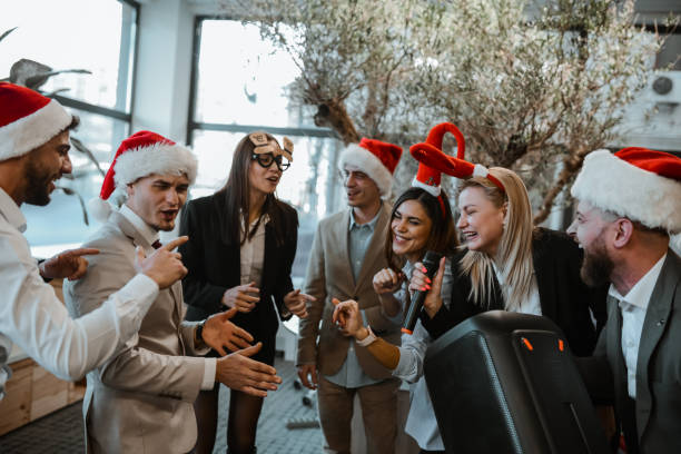 istock Business Colleagues Using Loudspeaker And Microphone While Singing Karaoke In Office For Christmas 1870336784