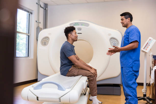 istock Caring mature male nurse explains CT scan to anxious patient 1870342576
