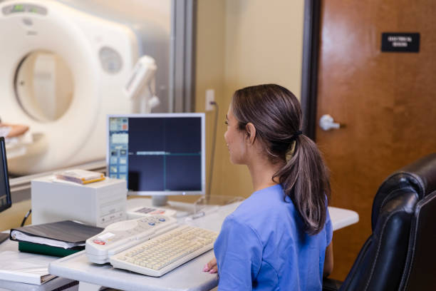 istock Confident radiographer prepares to send patient through CAT scan machine 1870342581