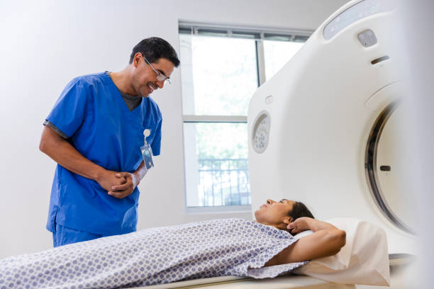 istock Male radiographer talks with anxious patient before CAT scan 1870342613