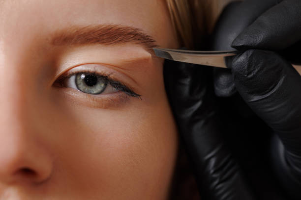 istock The master makes the client eyebrow correction with tweezers. 1870347973