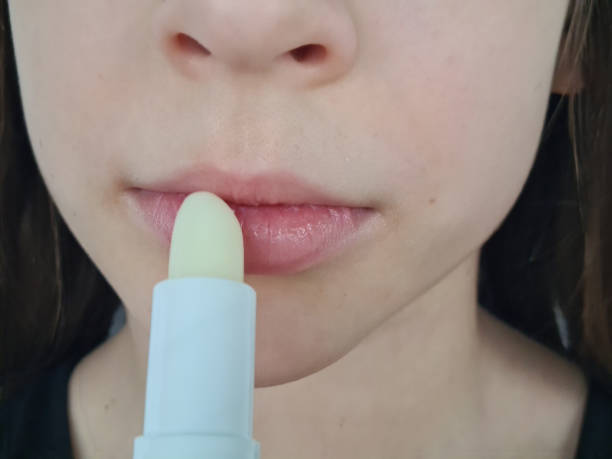 istock Little girl applying lip balm 1870349555