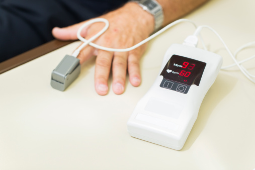 A hendheld pulse oximeter...patient at the doctor having tests