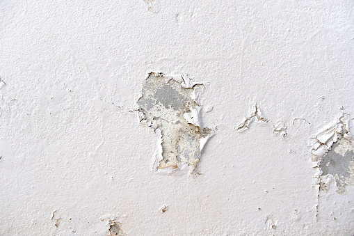 Peeling painted concrete wall. Leaking rain cause the wall cracked. Water damaged the wall.