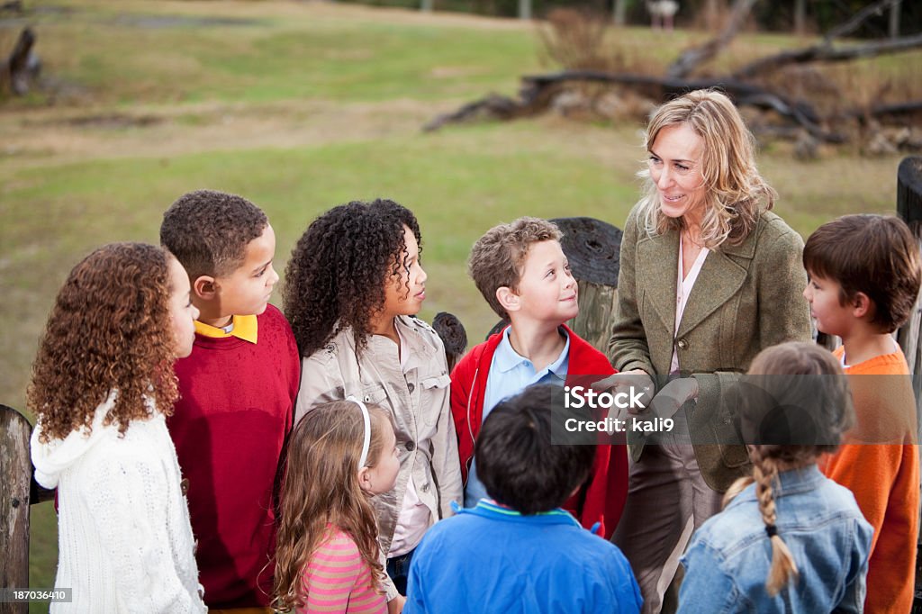 Insegnante con un gruppo di bambini in zoo - Foto stock royalty-free di Ambientazione esterna