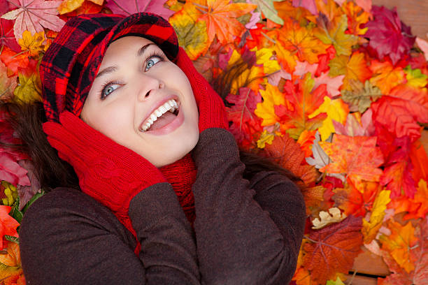 istock Young woman laying on autumn leaves 187036645