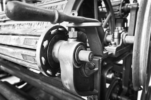 Black and white image of textile machine detail in manufacturing plant.