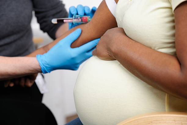 Bliska z African American kobieta w ciąży Bloods przyjmować – zdjęcie