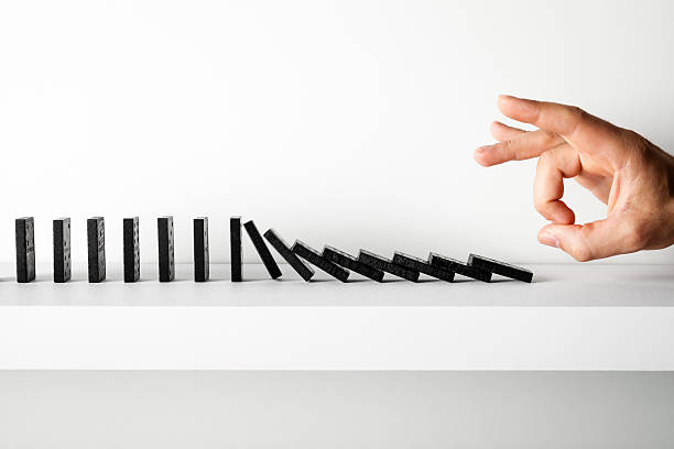 istock Hand pushing dominoes on shelf 187037143